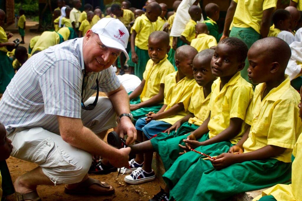 Volker Bassen fitting a shoe on a schoolchild during a community shoe distribution project on Kenya’s coast.